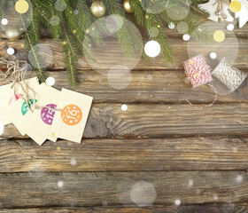 Advent calendar on a wooden background with space for copy, highlights, twigs. Beautiful Christmas background with blurred lights, sprigs of fir, cards. New Year's card with Advent calendar