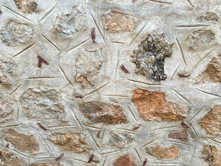 Background, texture, stone wall of round stones cobblestones bricks natural surface natural sharp convex rough stone cobblestone with cracks