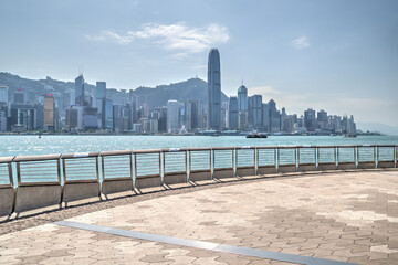 View of the skyscrapers and Victoria Harbour from the avenue of stars promenade in Tsim Sha Tsui, with hand prints of celebrities on the handrail, Hong Kong, China.
