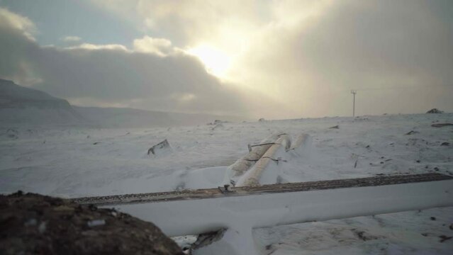 frozen pillar lying on the snow with sun in mountains 