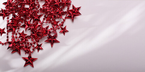 Red star garland fon light and shadow beige empty copy space background.