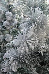 Close-up shot of artificial Christmas tree branches with artificial snow