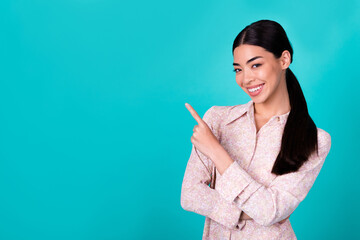 Portrait of cheerful pretty filipino person indicate finger empty space proposition isolated on turquoise color background