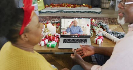 Senior african american couple with christmas decorations having video call with biracial man - Powered by Adobe