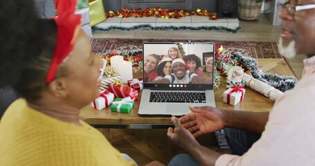 Senior african american couple having christmas video call with diverse people - Powered by Adobe