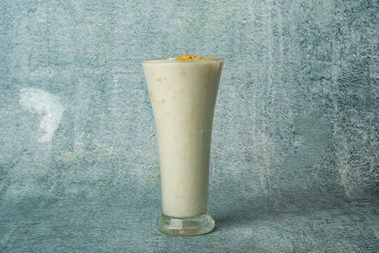 Fresh Malai Lassi served in a glass isolated on grey background top view of bangladesh food