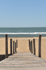 Panoramic view of a wooden path that leads to the beach. 