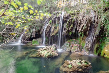 Pequeño lago llenándose con el agua de las cascadas que bajan a larga velocidad entre las rocas y...