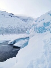 Northern landscape with frozen fountain in shape of blue ice hill in Khibiny mountains. Winter natural phenomenon. Kirovsk, Kola Peninsula, Murmansk region.