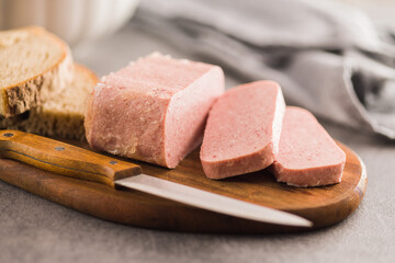 Luncheon meat on cutting board.