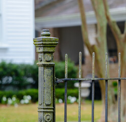 Vintage Ornamental Metal Fence Post and Section of Fence with Houses Across the Street Blurred in the Background