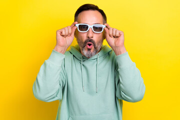 Naklejka premium Photo of mature age grey bristle beard man wear khaki sweater pouted lips shocked wear 3d goggles visual effects isolated on yellow color background
