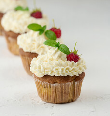 Baked cupcakes with white butter cream on the table, delicious dessert