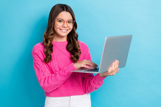 Photo of young smart cute academic schoolgirl browsing more education information about homework exercise isolated on blue color background