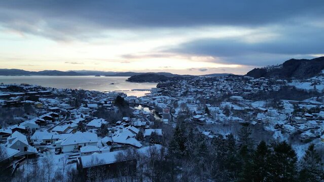 Flight toward the harbor of the coastal town of Os&oslash;yro, Bj&oslash;rnafjorden, Norway during winter. Sunset.