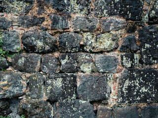 Texture of old black and grey masonry stone wall. Ancient grunge brick-stones background.
