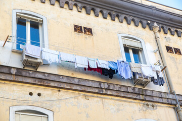 Fototapeta na wymiar Things are dried on a rope through the window. Typical drying of clothes in the South of Italy