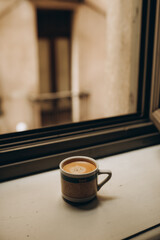Coffee cup near the window with shutters in Turin, Italy.