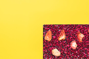 Handmade chocolate with red berries on yellow background