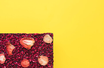 Handmade chocolate with red berries on yellow background