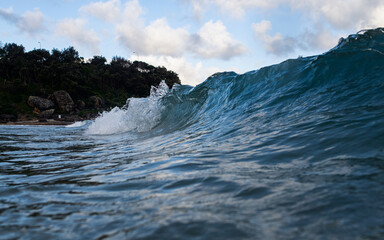 Small wave barrel breaking on the shore.