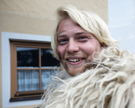 Cheerful smiling young man in sheepskins at the Krampus procession, Austria, Salzburg