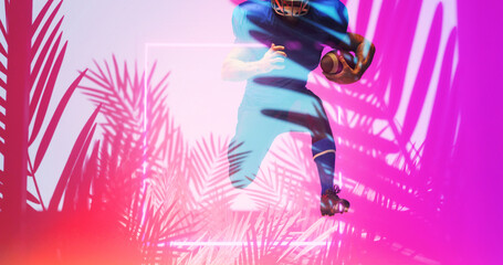 Fototapeta na wymiar American football player with ball running by illuminated square and pink plants, copy space