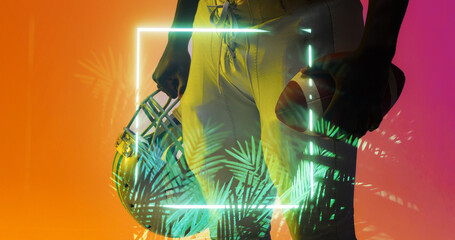 Midsection of american football player holding ball and helmet by illuminated square and plants