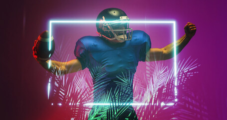 American football player raising arms while standing by illuminated rectangle and plants