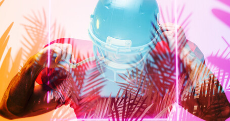 Close-up of american football player wearing helmet by illuminated square and plants