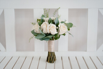bouquet of white roses on a white wooden bench