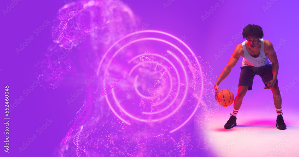 Poster composite of biracial male player playing basketball by illuminated circular and abstract pattern