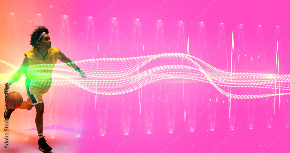 Poster biracial player dribbling basketball over illuminated wave and zig zag pattern on pink background