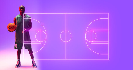 Naklejka premium Composite of bald african american player with ball standing by illuminated basketball court