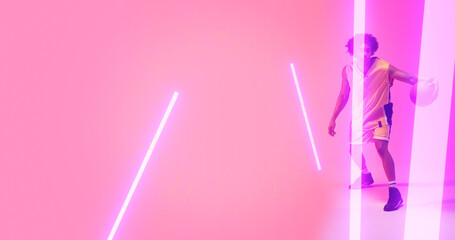 Composite of biracial basketball player dribbling ball with illuminated lights on pink background