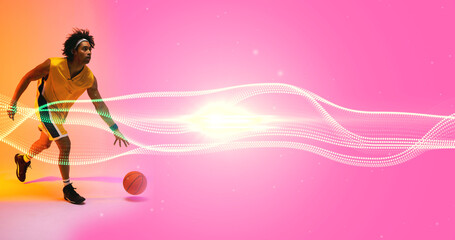 Composite of biracial male player playing with ball by illuminated wave pattern on pink background