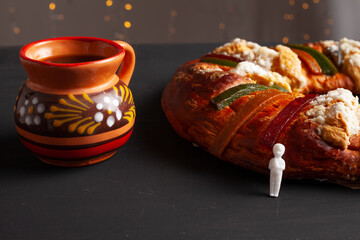 Traditional rosca de reyes and coffee on black background