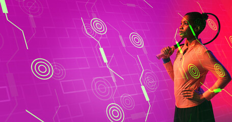 Side view of biracial female player with racket standing on illuminated connected lines and circles