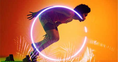 Side view of biracial female athlete running from starting position by illuminated plants and circle