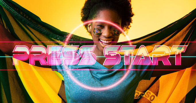 Happy biracial female soccer player with brazilian flag over illuminated press start text and circle