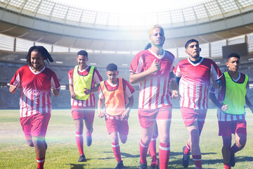 Team of multiracial male soccer players in sports clothing running in stadium © vectorfusionart