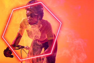 Hexagon neon over dedicated african american cyclist riding bicycle against orange background