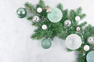 Christmas tree branch with snow and ice balls on a silver background