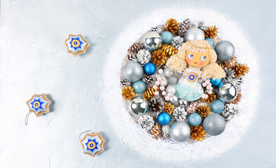 Christmas wreath with a handmade angel on a silver background