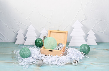 Composition with paper Christmas trees and balls in a wooden box