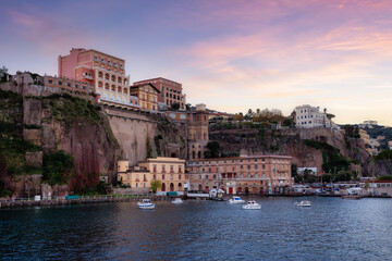 Fototapeta na wymiar Homes and Hotels in a touristic town on the seafront. Sorrento, Compania, Italy. Colorful Sunrise Sky Art Render.