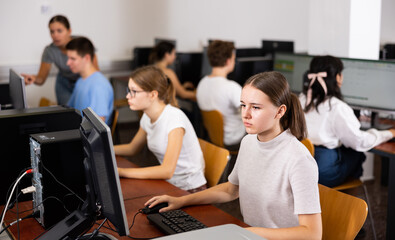 Fototapeta premium Teenager girl using computer during computer sciene lesson in school.