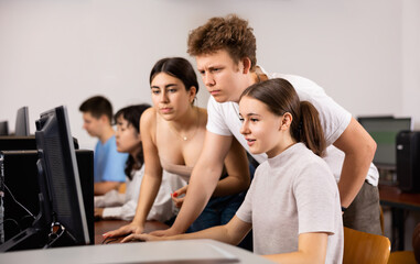 Fototapeta premium Portrait of female and male students working on computers in class room