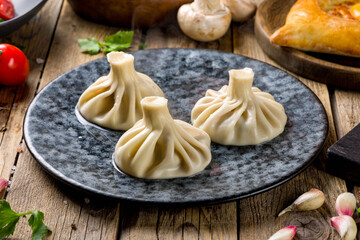 Khinkali with lamb on beautiful plate on wooden table