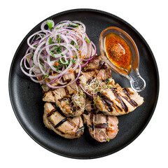 Kebab of pork with red onion and tomato sauce on black plate top view isolated on white background